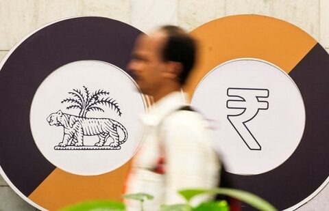 A man walks past a logo of the Reserve Bank of India (RBI) and the Indian Rupee inside the RBI headquarters in Mumbai. (Reuters)