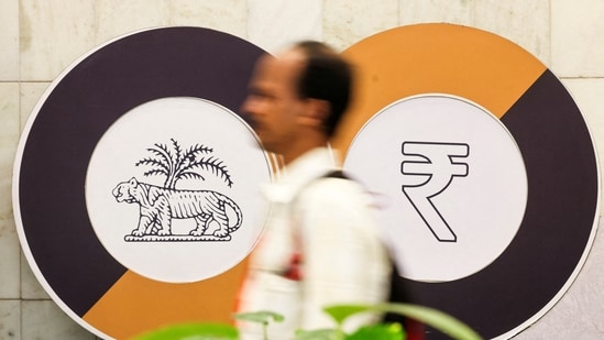 A man walks past a logo of the Reserve Bank of India (RBI) and the Indian Rupee inside the RBI headquarters in Mumbai. (Reuters)