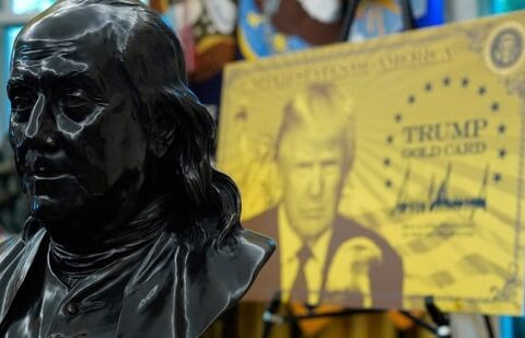 How it works, does it help land a Green Card, and other questions answered| Business News A bust of Benjamin Franklin, one of the founding fathers of the US, near a poster for the Trump Gold Card in the Oval Office of the White House (AP)
