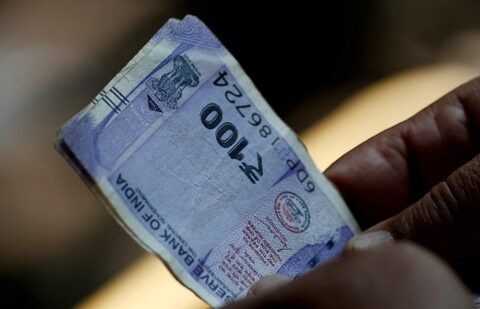 FILE PHOTO: A customer holds hundred rupees Indian currency notes near a roadside currency exchange stall in New Delhi, India, May 24, 2024. REUTERS/Priyanshu Singh/File Photo (REUTERS)