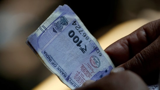 FILE PHOTO: A customer holds hundred rupees Indian currency notes near a roadside currency exchange stall in New Delhi, India, May 24, 2024. REUTERS/Priyanshu Singh/File Photo (REUTERS)