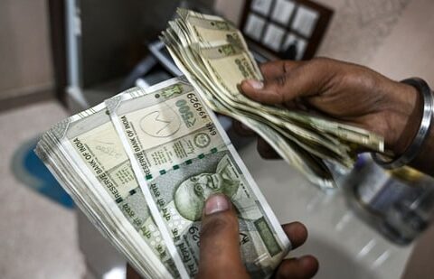 An employee counts 500 rupee banknotes at a currency exchange in New Delhi, India. (Bloomberg)