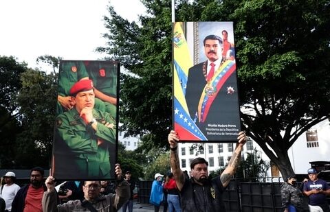 Wall Street Investors Who Stuck With Venezuela Are Poised for a Payday| Business News Supporters of Nicolás Maduro and Hugo Chávez, in beret, held up their images in Caracas over the weekend after the U.S. seized Maduro.