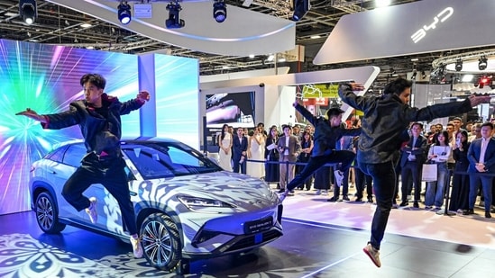 Chinese EVs Blow Past Tesla and Tariffs En Route to Global Reign| Business News Performers drawing attention to a BYD Sealion 7 electric vehicle at the Singapore motor show in Singapore last year.