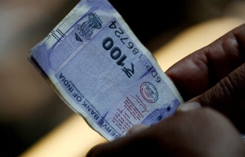 What explains the spike in bond yields despite 125 bps in RBI repo rate cuts| Business News A customer holds ₹100 notes near a roadside currency exchange stall in New Delhi. (Reuters)