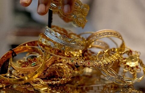 A goldsmith weighs gold jewellery inside a showroom in Ahmedabad, India. (REUTERS)