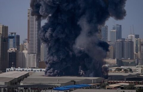 A black plume of smoke rises from a warehouse in the industrial area of Sharjah City following reports of Iranian strikes in Dubai on 1 March 2026. (AP)