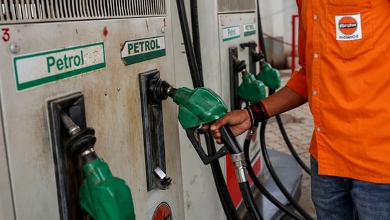 Oil marketing firms suspend fuel on credit to pumps amid West Asia crisis| Business News A petrol pump attendant picks up a nozzle to refuel a vehicle at an Indian Oil fuel station in Varanasi. (AFP)
