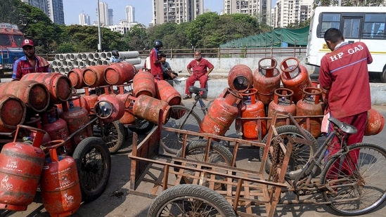 Workers load LPG cylinders in a cart in Mumbai on Wednesday, 11 March 2026. The government has raised LPG cylinder prices for the first time in nearly a year to  ₹913. (PTI)