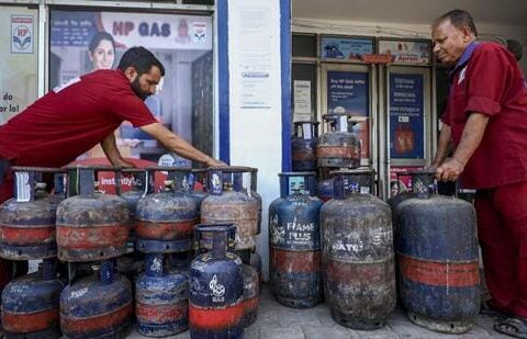 Workers stack LPG cylinders at a gas agency in Jammu. (PTI)