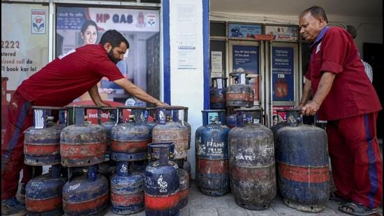 Workers stack LPG cylinders at a gas agency in Jammu. (PTI)