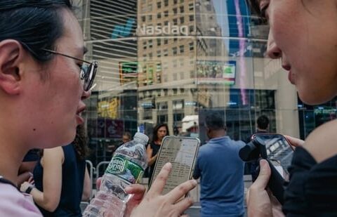 People monitoring stock prices on their phones as SpaceX shares began trading Friday.