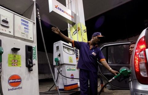 A worker fills a car with petrol as he gestures towards the fuel barometer for the passenger to check, at a fuel station in Kolkata. (Reuters File)