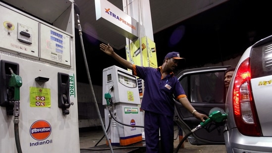 A worker fills a car with petrol as he gestures towards the fuel barometer for the passenger to check, at a fuel station in Kolkata. (Reuters File)
