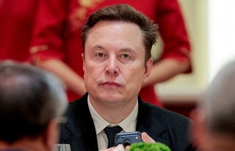 FILE PHOTO: Tesla CEO Elon Musk holds a mobile phone as he arrives to attend a state banquet with U.S. President Donald Trump and Chinese President Xi Jinping at the Great Hall of the People in Beijing, China, May 14, 2026. REUTERS/Evan Vucci/File Photo (REUTERS)