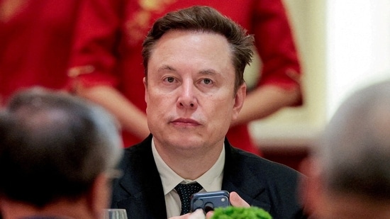 FILE PHOTO: Tesla CEO Elon Musk holds a mobile phone as he arrives to attend a state banquet with U.S. President Donald Trump and Chinese President Xi Jinping at the Great Hall of the People in Beijing, China, May 14, 2026. REUTERS/Evan Vucci/File Photo (REUTERS)