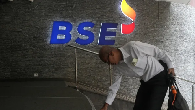 Sensex, Nifty open flat as Middle East tensions keep crude above $100 A man touches the stairs as he arrives at the Bombay Stock Exchange (BSE) building in Mumbai (REUTERS/File)