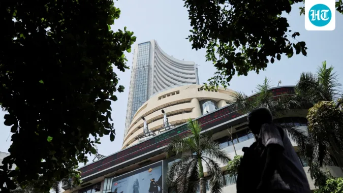 Men walk past a screen displaying market results outside the Bombay Stock Exchange (BSE) in Mumbai. (REUTERS)
