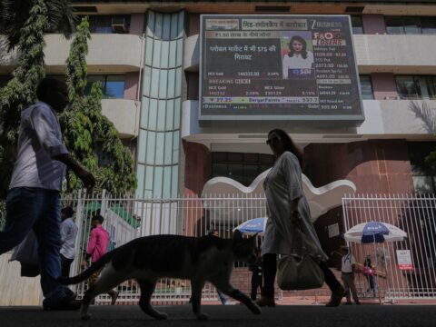 People watch the stock market index on a display screen on the facade of the Bombay Stock Exchange (BSE) building in Mumbai (AP/file)
