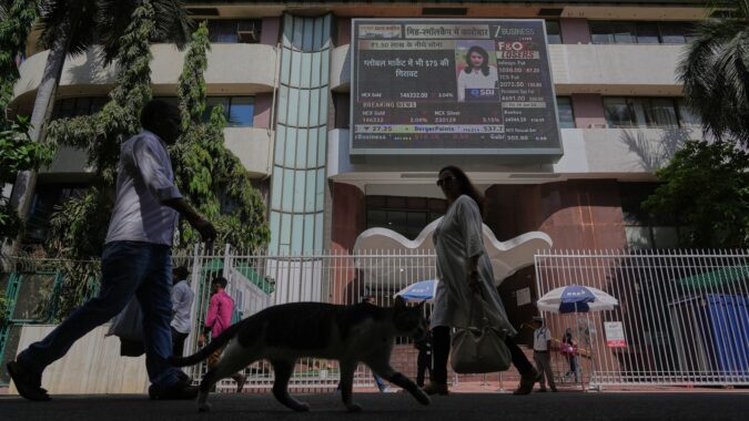 People watch the stock market index on a display screen on the facade of the Bombay Stock Exchange (BSE) building in Mumbai (AP/file)