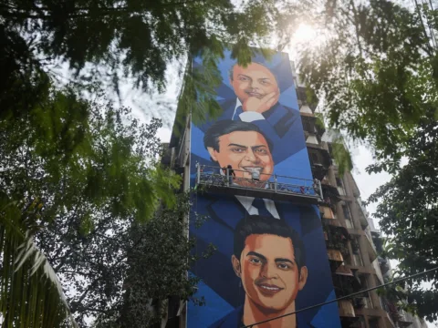 An artist paints a mural featuring Reliance Industries founder Dhirubhai Ambani, Reliance Industries Chairman and Managing Director Mukesh Ambani, and Reliance Jio Infocomm Limited Chairman Akash Ambani. (Representative Image/Reuters)
