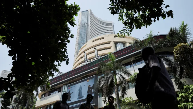 File: Men walk past a screen displaying market results outside the Bombay Stock Exchange (BSE) in Mumbai (REUTERS)