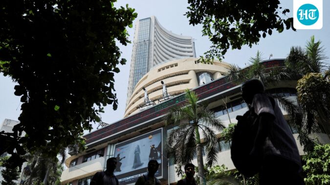 Men walk past a screen displaying market results outside the Bombay Stock Exchange (BSE) in Mumbai (Reuters File)